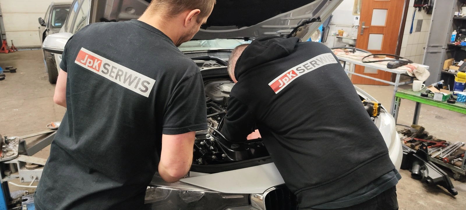 Mechanicy naprawiający samochód w warsztacie JpK Serwis we Wrocławiu